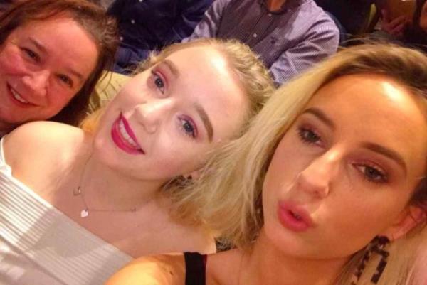 Linda and her two daughters, pouting and smiling to camera