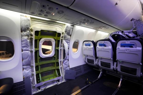 An Alaska Airlines Boeing 737 Max 9 aircraft with paneling removed exposing door plug area, awaiting inspection at Seattle-Tacoma Internatio<em></em>nal Airport