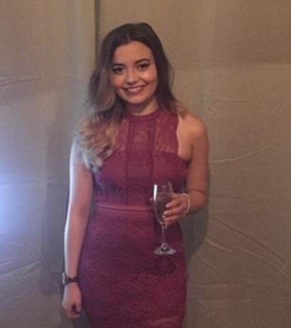 A woman, Lucy Jones, wearing a burgundy dress and holding a glass of wine.
