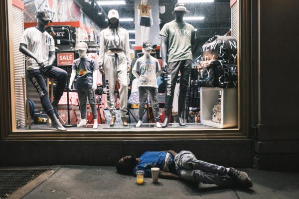 Homeless man sleeps on the street of Times Square.