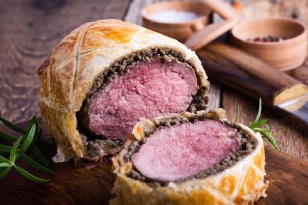 Beef Wellington, classic steak dish on rustic wooden table