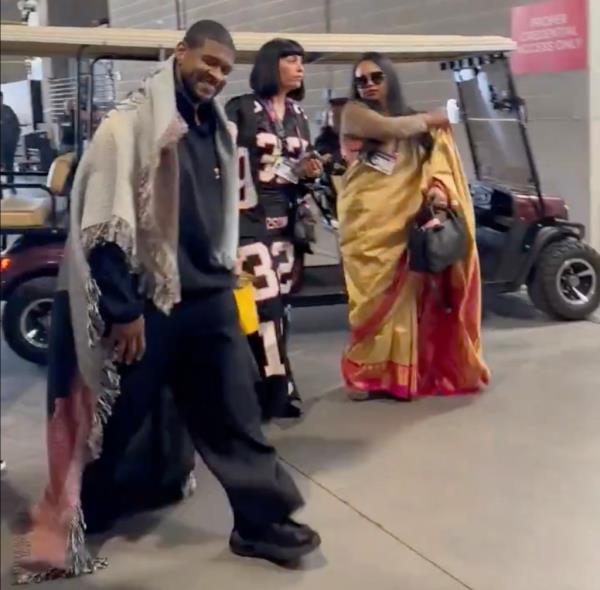 Usher smiling in a blanket. 