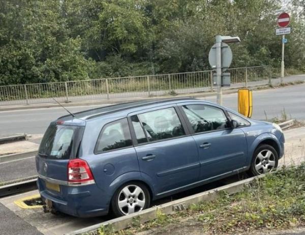 A car getting stuck in the bus lane trap at the junction of Station Road and Harrison Way in St Ives, Cambs. Photo released October 13 2023. See SWNS story SWLNtrap. Dozens of motorist are complaining their cars are being damaged after being caught in a co<em></em>ntroversial bus lane trap. The trap is located at the junction of Station Road and Harrison Way in St Ives, Cambs and is designed to prevent vehicles driving o<em></em>nto the busway. The pit in the road is wide enough that small vehicles fall into it but small enough that larger-diameter-wheeled vehicles, such as buses, may pass. But as of late, it could be argued the trap is proving a little too effective, with drivers getting stuck in it o<em></em>nce or twice a week.