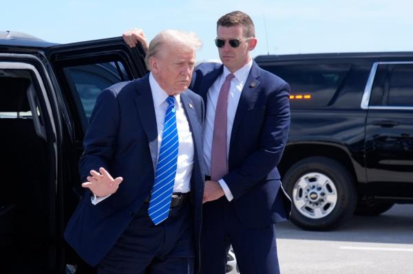 Trump waves as he arrives to board his plane at Palm Beach Internatio<em></em>nal Airport before heading to Nashville. 