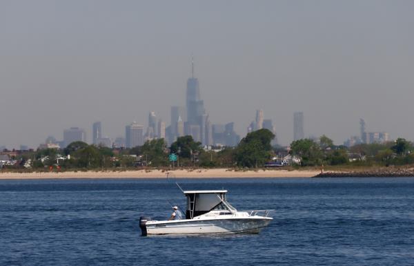 Man fishing in Jamaica Bay with One World Trade Center and lower Manhattan in the background