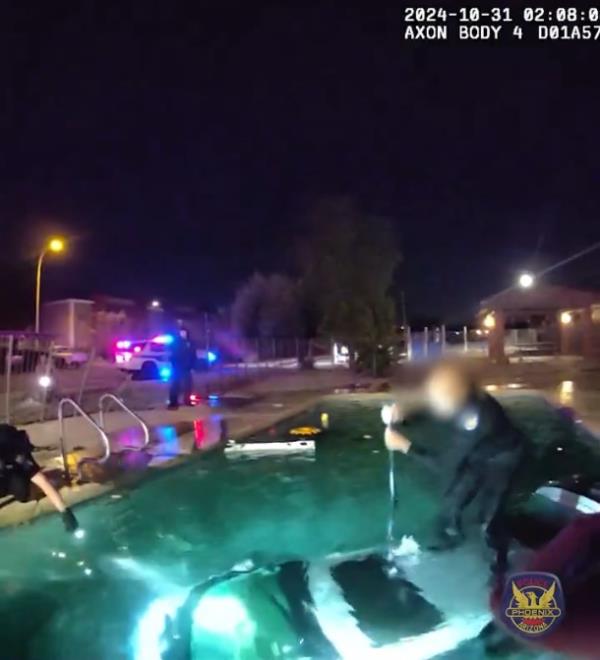 A screengrab of police body cam footage that shows the driver rescued from the submerged car.