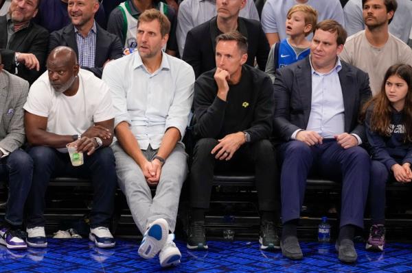 Former NFL football running back Emmitt Smith, left, sits with former NBA basketball players Dirk Nowitzki, second from left, and Steve Nash, second from right, and businessman Patrick Dumont, right, during the second half in Game 3 of the NBA basketball finals between the Dallas Mavericks and the Boston Celtics.