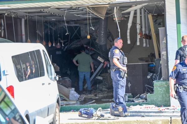 Police officer investigating a scene wher<em></em>e a vehicle crashed into a Long Island nail salon causing fatal injuries
