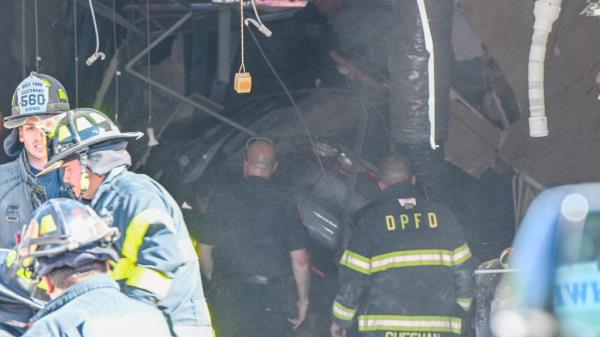Firefighters and ambulance crews at the scene of a vehicle crash into the Hawaii Nail & Spa building on Grand Boulevard, with casualties and damages evident.