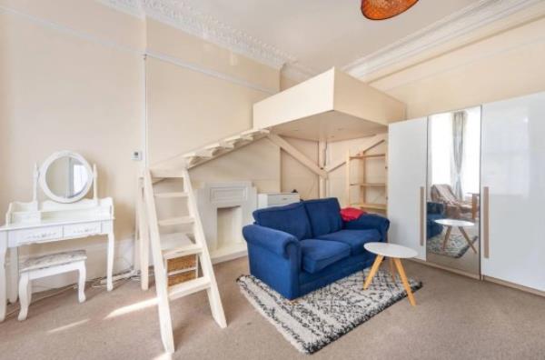 It has a staircase that leads to a box bed that seems to be floating above the sofa