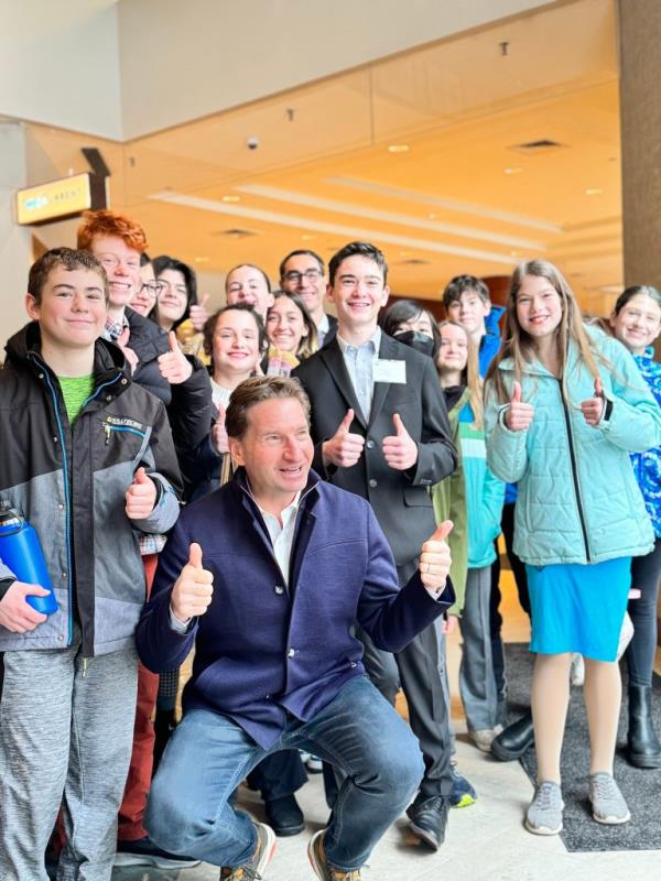 Dean Phillips poses with attendees of the New England College Co<em></em>nvention outside the DoubleTree hotel in Manchester