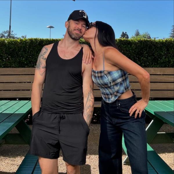 Nikki Bella kisses Artem Chigvintsev's cheek during happier times.