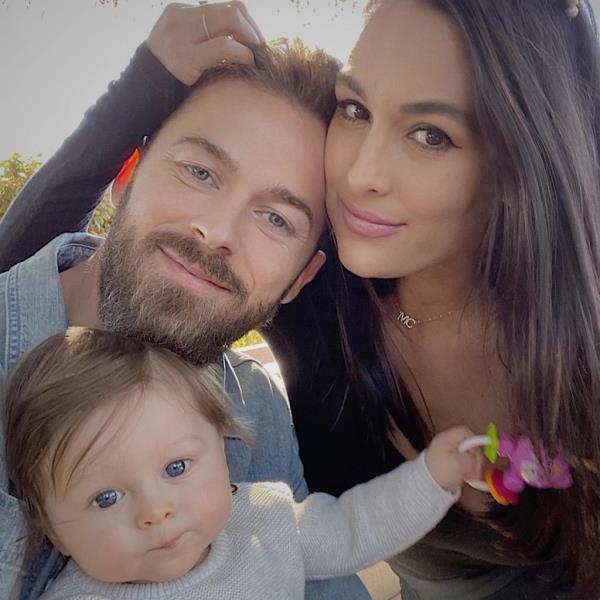 Nikki Bella and Artem Chigvintsev with their child.