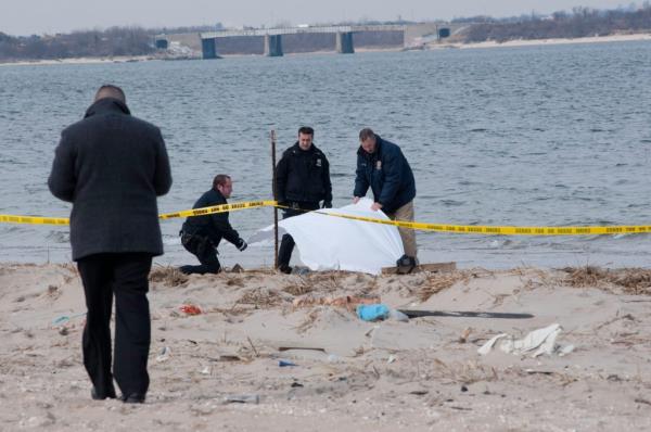Police inspect a female body that washed up near Bayside Ave in the Rockaways.