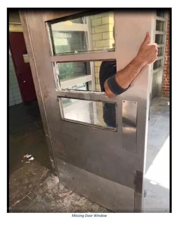 A building entrance with an open door and a broken lock due to faulty security found in a NYCHA development report.