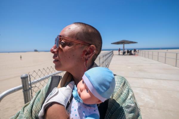 a homeless person holding a baby doll
