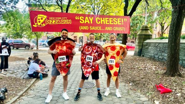 three people in pizza costumes outside of nyc pizza run start line