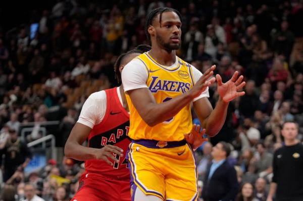 Lakers guard Bro<em></em>nny James (9) looks for a pass as Toro<em></em>nto Raptors guard Ja'Kobe Walter (14) defends during the second half at Scotiabank Arena. 
