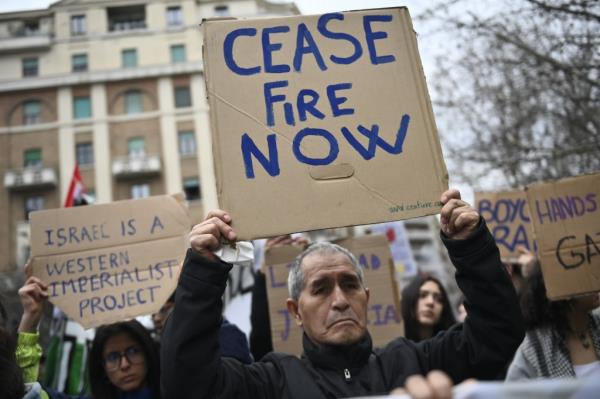 A man holds up a sign that says, 