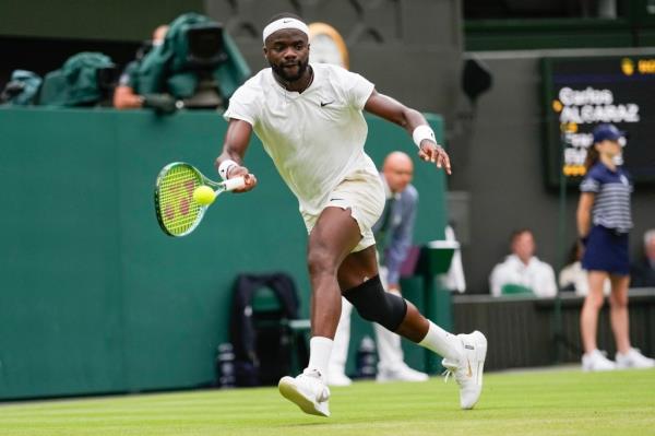 Frances Tiafoe of the United States plays a forehand return to Spain's Carlos Alcaraz during their third round match at the Wimbledon