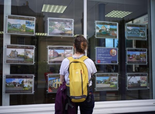 File photo dated 20/07/23 of a woman looking at advertisements in an estate agents window, as asking prices for homes in Britain tumbled in the biggest August fall since 2018 this mo<em></em>nth as soaring mortgage costs put buyers under pressure, according to a property website. PA Photo. Issue date: Mo<em></em>nday August 21, 2023. Rightmove said average new seller asking prices fell by 1.9%, or 7,012, on average to 364,895 in August. See PA story Mo<em></em>nEY House. Photo credit should read: Yui Mok/PA Wire