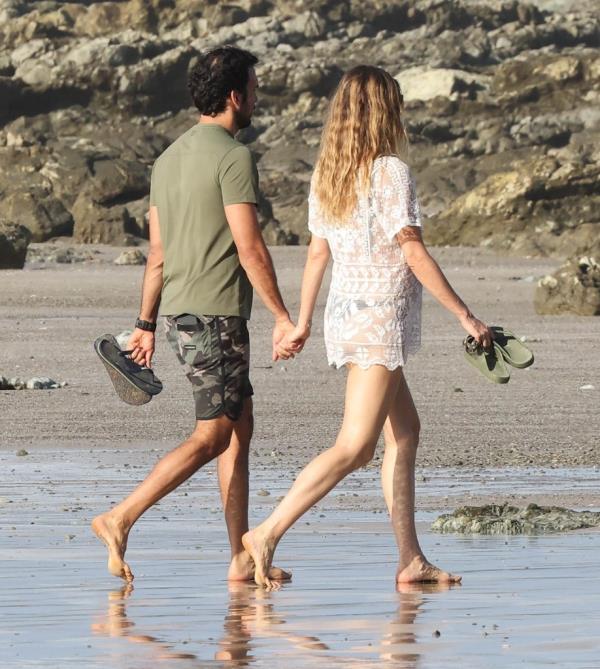 Gisele and Joaquim walk hand in hand.