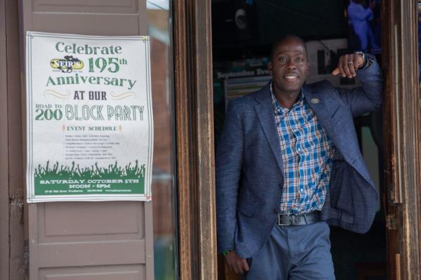 Gordon standing next to a sign for Neir's birthday party.