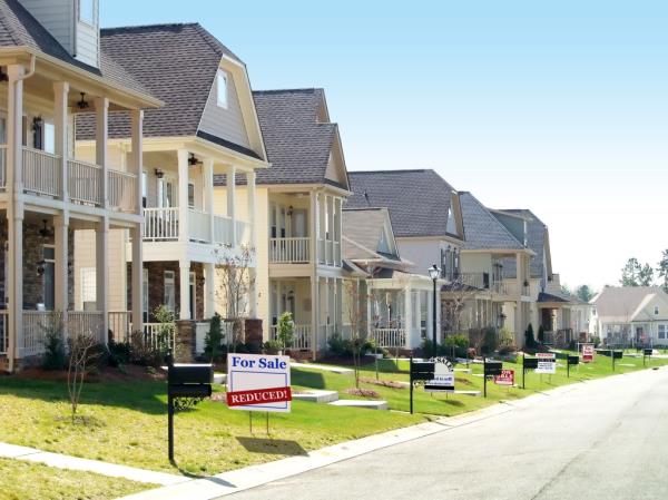 Row of nice homes for sale on a street with signs indicating foreclosure