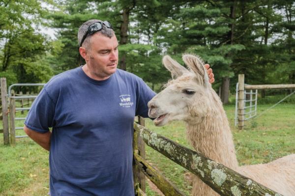 Brent Walker, owner of WoodsEdge Farm, with a llama. 