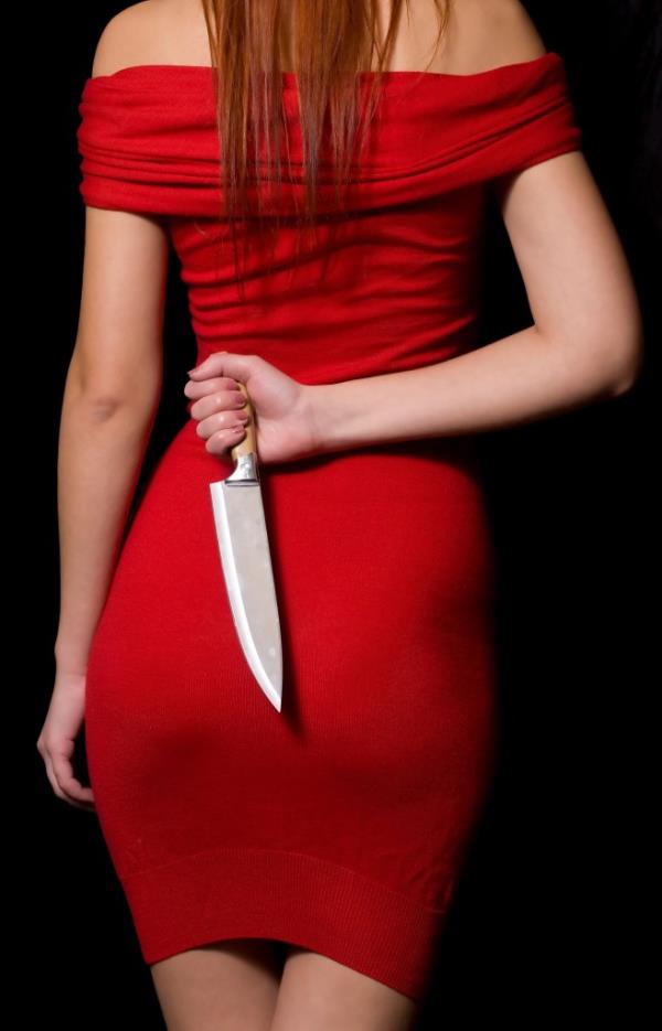 A woman with a knife behind her back.