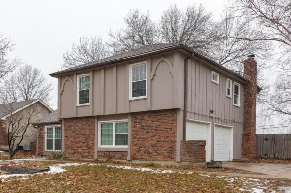 A house with a garage and driveway in Kansas City, MO, the site wher<em></em>e three men were found deceased in the backyard