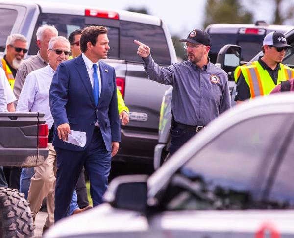 Florida Governor Ron DeSantis, left gets a tour from Florida Division of Emergency Management Director Kevin Guthrie, center, while talking a<em></em>bout the heavy machinery staging area at the Florida Horse Park in Ocala, Fla. Tuesday afternoon, October 8, 2024, before a press co<em></em>nference along with Florida Department of Transportation Secretary Jared Perdue.