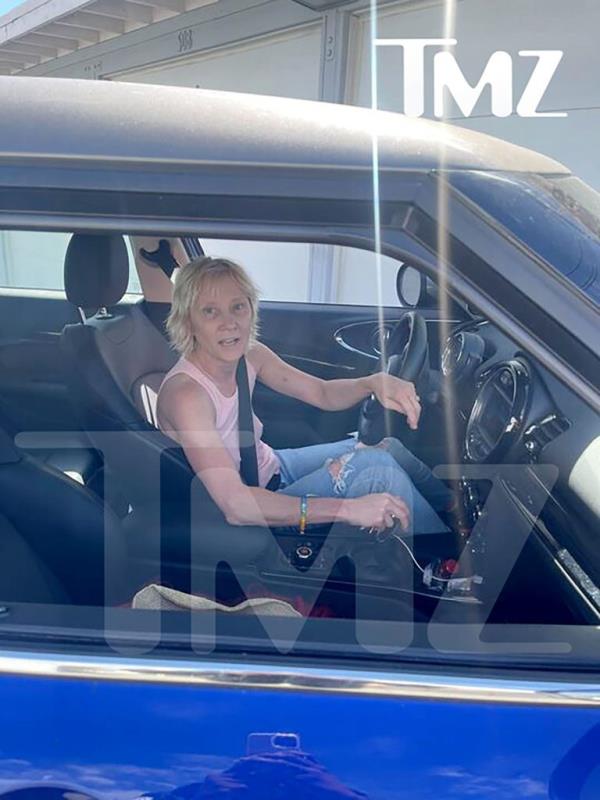 Actress Anne Heche involved in a car crash, visibly distressed and taken away on a stretcher, with a suspected bottle of alcohol in the car