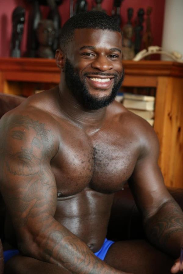 Darren Sho<em></em>neye smiling while sitting down and shirtless wearing underwear