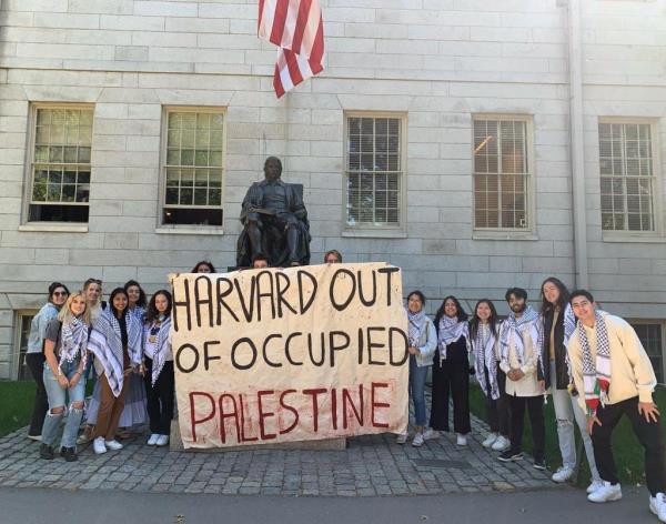 Harvard students pose with sign in support of Palestine