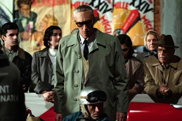 Adam Driver wearing sunglasses with short grey hair. 