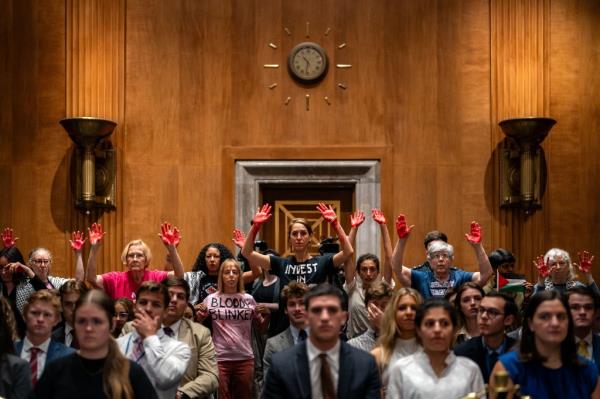 Pro-Palestinian demo<em></em>nstrators hold painted hands as U.S. Secretary of State Antony Bl<em></em>inken started to speak.</p>

<p>　　