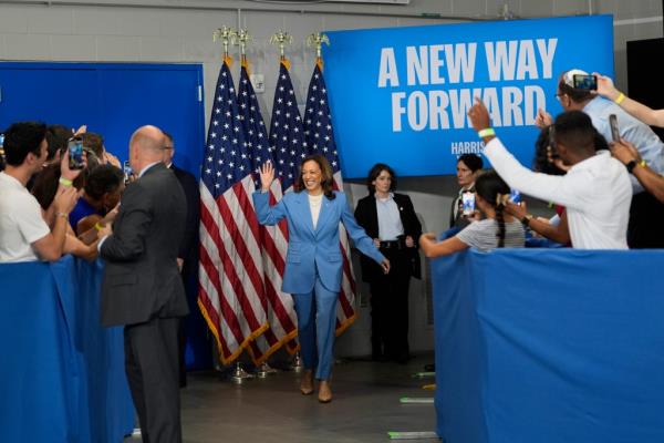 Vice President Kamala Harris in blue suit waving to crowd at campaign event in Raleigh, N.C., 2024