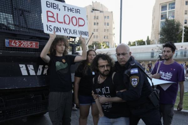 An Israeli police officer removes a demo<em></em>nstrator blocking a road during a protest calling for a deal for immediate release of hostages held in the Gaza Strip by the Hamas militant group, in Jerusalem.