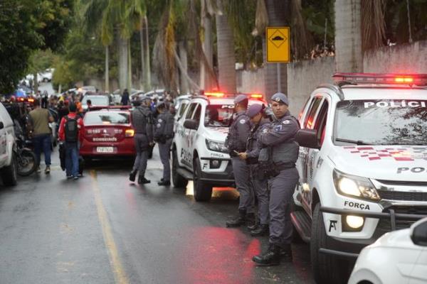 Police stand along the street leading to the gated community wher<em></em>e a plane crashed in Vinhedo, Sao Paulo state, Brazil.