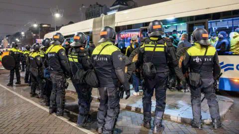 VLN NIEWS/ANP/AFP Police in riot gear guard a Dutch bus in Amsterdam
